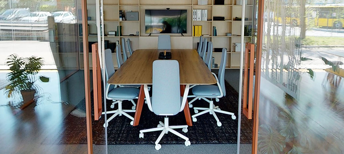 Nia chairs at an Immerse conference table within a glass walled space offers a private meeting room for up to ten people.