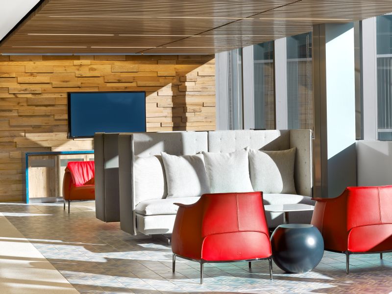Haworth Archibald red leather lounge chairs and grey couch by the window