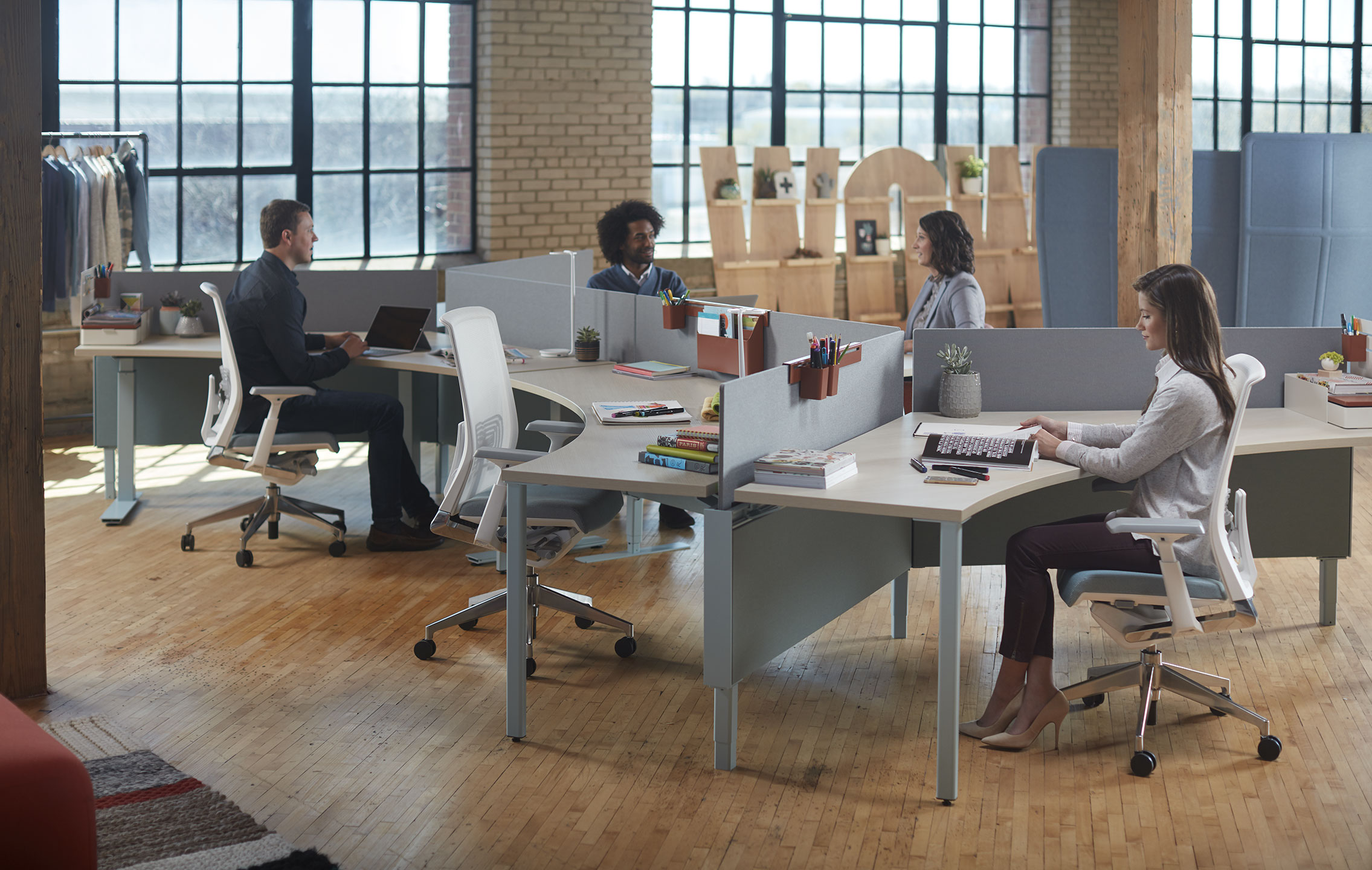 Haworth Compose Connections workspace divider in grey in an office area with employee working at desk with brick walls and wood floor
