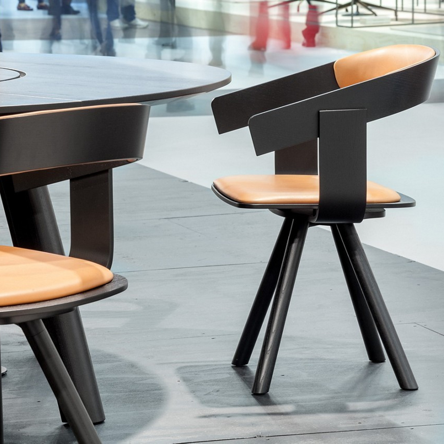 Haworth Buzzifloat chair in black wood and tan leather seating at a cafe